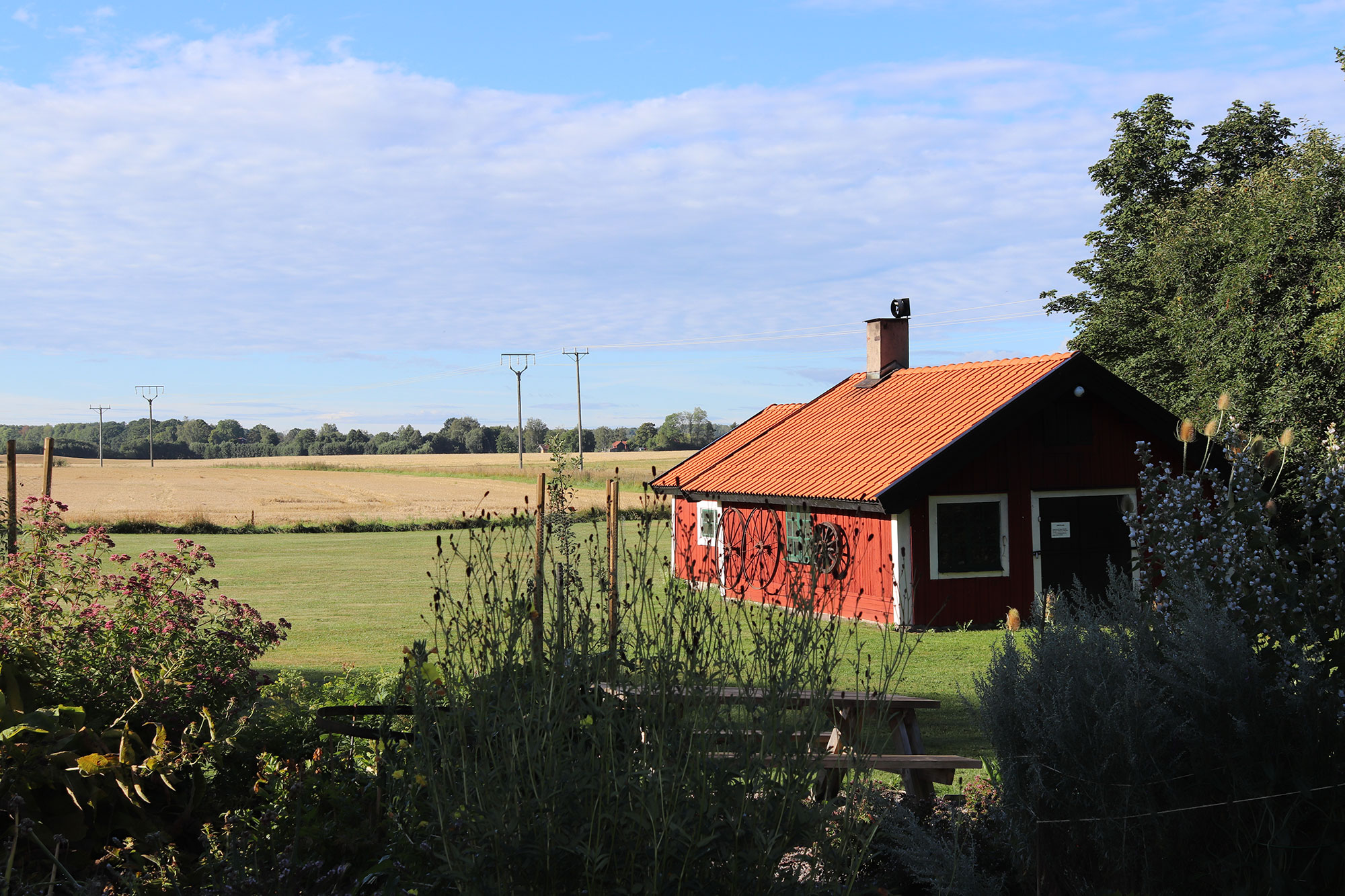 Ett rött hus med ett fält i bakgrunden
